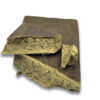 Moroccan Gold import style hash slab with broken pieces showing sandy-gold interior and soft crumbly texture
